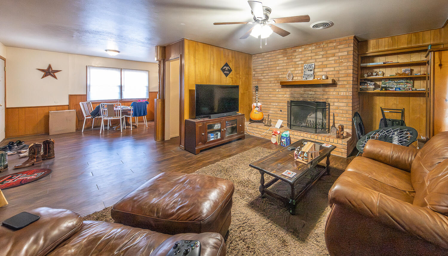 2408 33rd Street Lubbock, TX 79411 - Photo 28 of 31 a living room with furniture flat screen tv and a fireplace