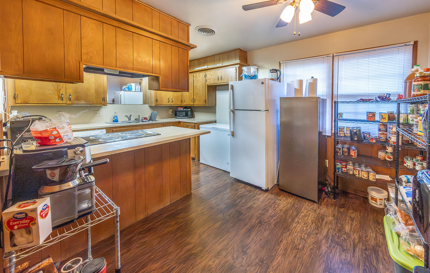 2408 33rd Street Lubbock, TX 79411 - Photo 7 of 31 a kitchen with stainless steel appliances wooden floors and wooden cabinets