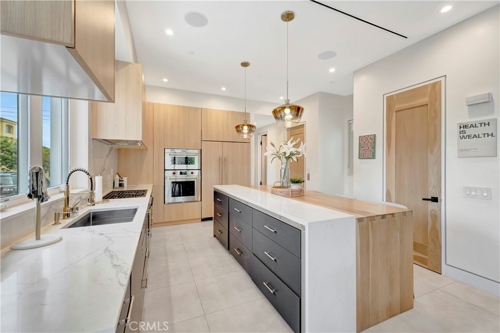 620 Huntington Street Huntington Beach, CA 92648 - Photo 14 of 65 a large kitchen with kitchen island a large counter space a sink stainless steel appliances and cabinets