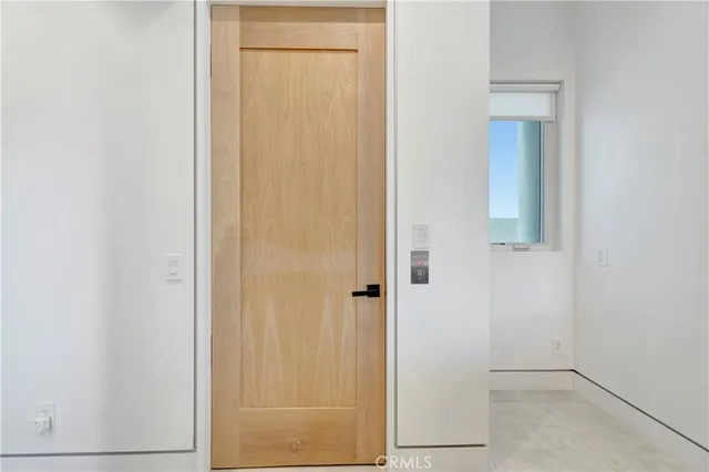 a bed sitting in a spacious bedroom next to a window