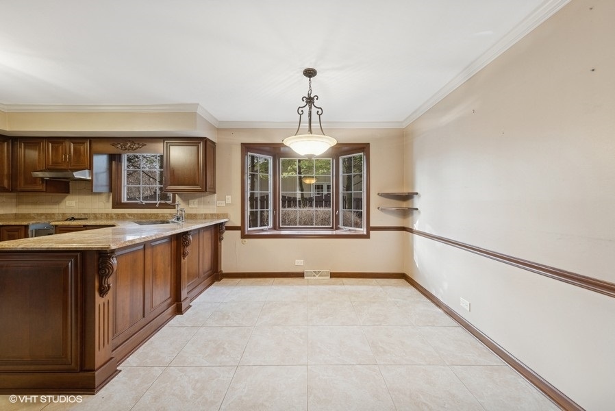 314 Fuller Road Hinsdale, IL 60521 - Photo 7 of 21 a large kitchen with kitchen island granite countertop wooden cabinets a granite counter tops and a window