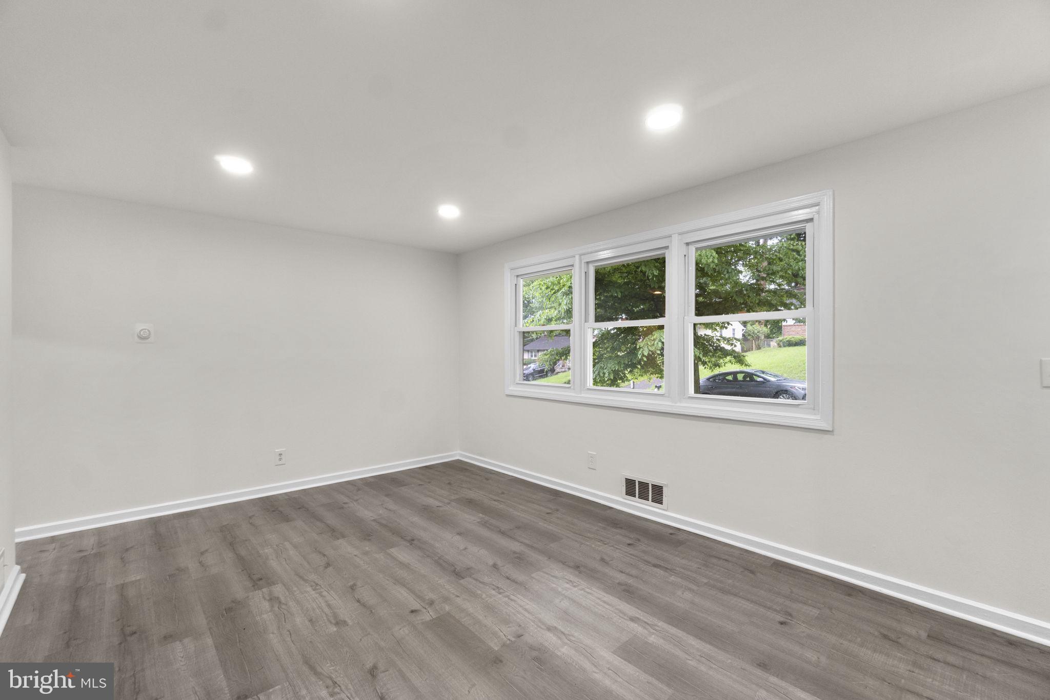 3658 Clifmar Road Baltimore, MD 21244 - Photo 11 of 43 an empty room with wooden floor and windows
