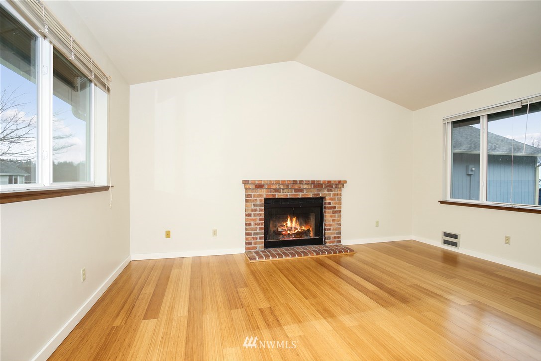 1216 223rd Street Southwest Bothell, WA 98021 - Photo 5 of 22 a view of empty room with wooden floor and fireplace