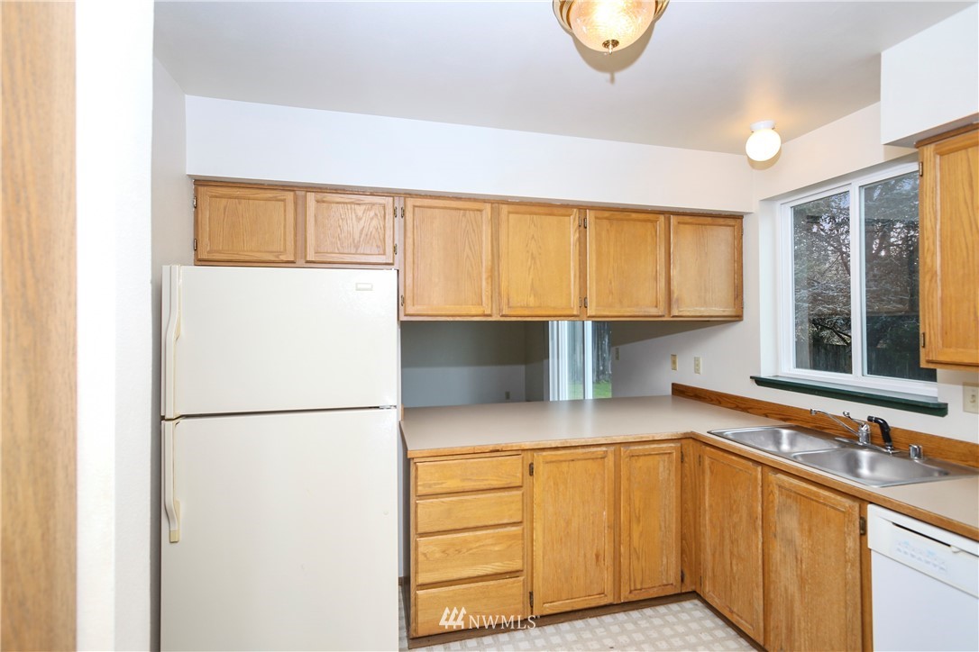 1216 223rd Street Southwest Bothell, WA 98021 - Photo 8 of 22 a kitchen with stainless steel appliances granite countertop a refrigerator sink and cabinets