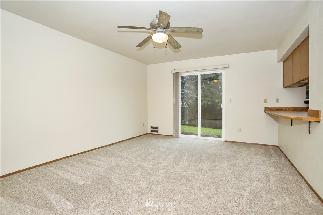 1216 223rd Street Southwest Bothell, WA 98021 - Photo 10 of 22 an empty room with a chandelier fan and windows