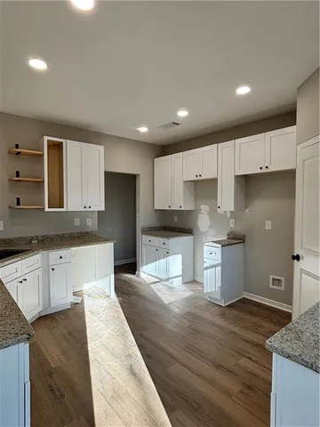 a large kitchen with stainless steel appliances granite countertop a stove a sink and a refrigerator