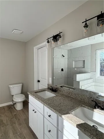 a bathroom with a granite countertop sink a toilet and a bathtub