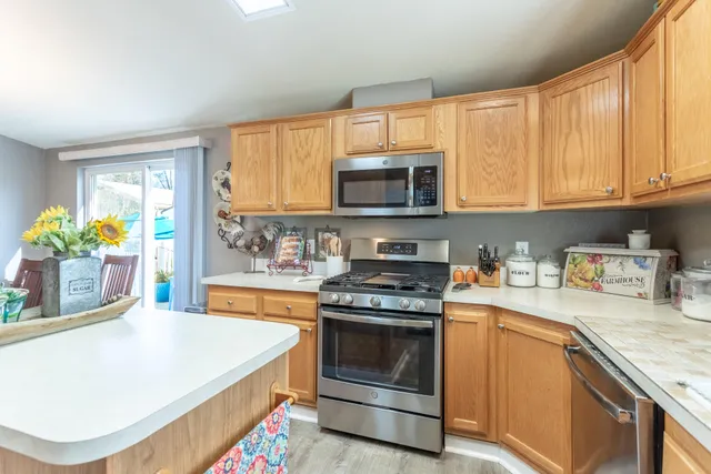 a kitchen with stainless steel appliances granite countertop a stove a sink and a microwave