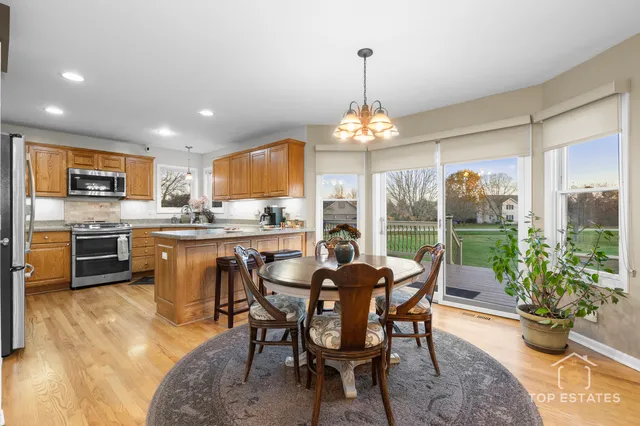 a dining room with furniture a chandelier and kitchen view
