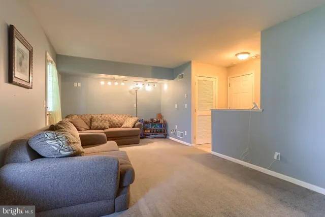 a living room with furniture and a chandelier
