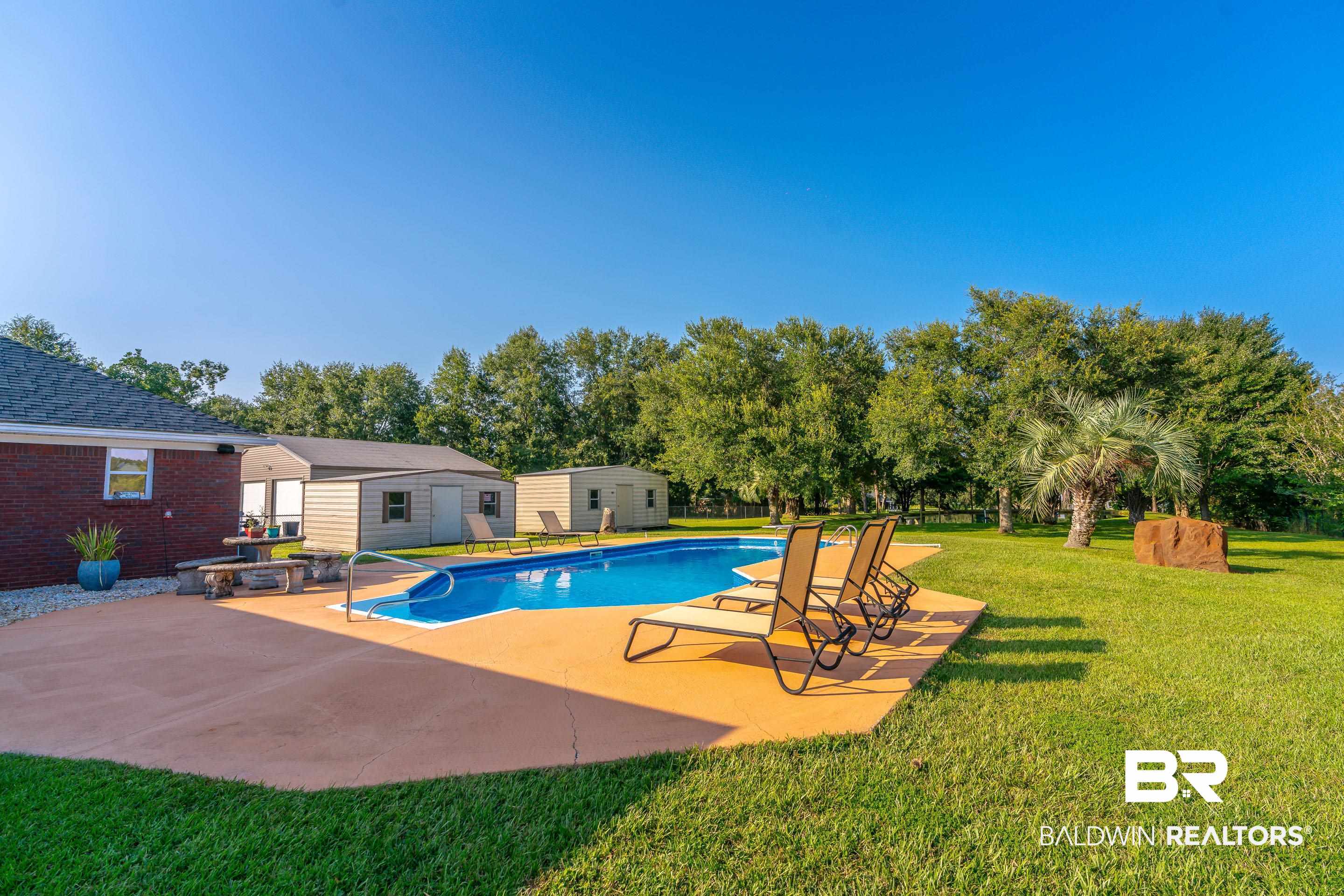9477 Deerfield Drive Irvington, AL 36544 - Photo 48 of 58 View of pool featuring a patio and a lawn