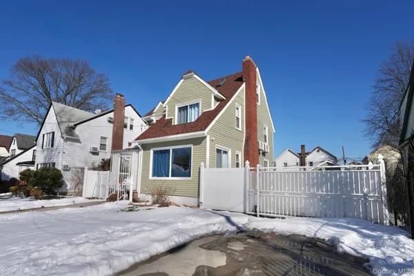 a view of a house with a yard and large trees
