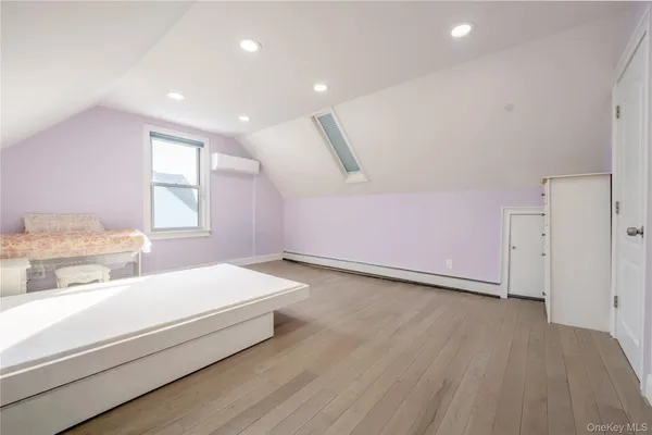 a spacious bedroom with a bed and a dresser
