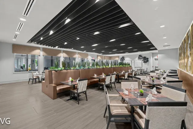 a dining room with wooden floor a chandelier a wooden table and chairs