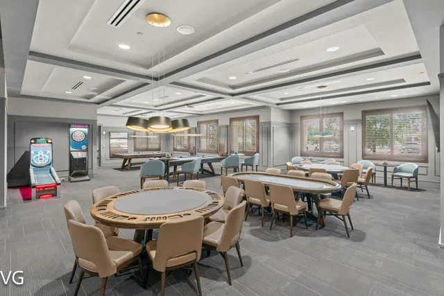 a living room with furniture with floor to ceiling windows and a chandelier