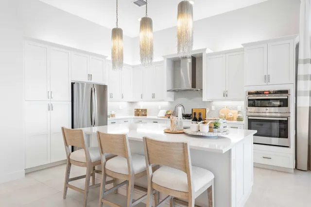 a kitchen with stainless steel appliances a stove a sink island and a refrigerator