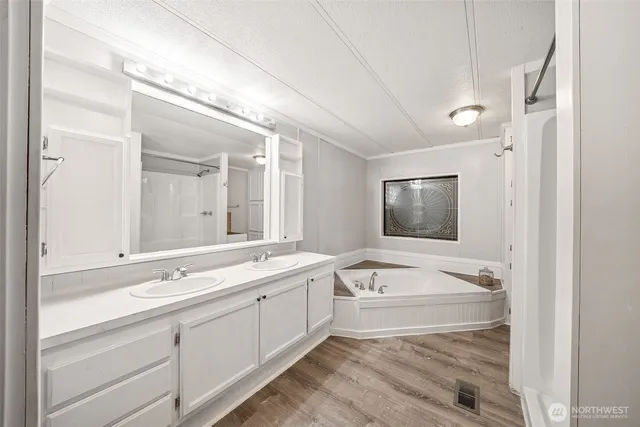 a bathroom with a sink a large mirror and a bathtub