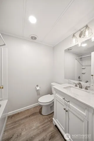a bathroom with a granite countertop sink a toilet and a mirror