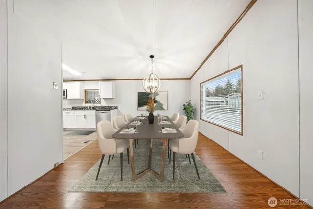 a dining room with wooden floor and white walls