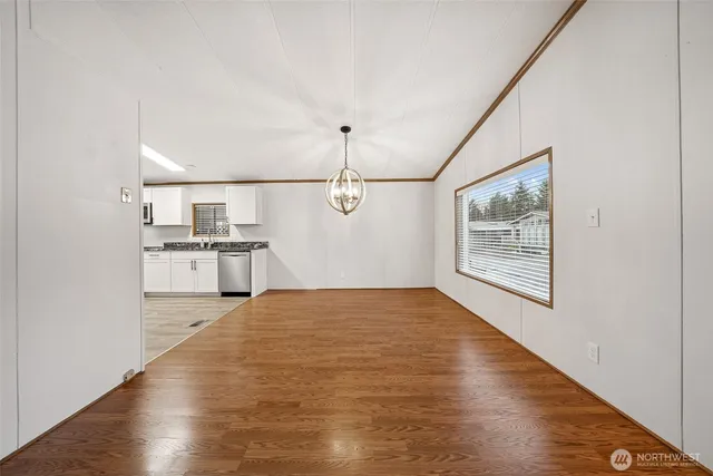 a view of a kitchen with wooden floor electronic appliances and windows