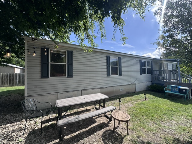 106 Ramirez Street Kyle, TX 78640 - Photo 3 of 19 A manufactured home with charming outdoor seating offers an inviting backyard retreat.