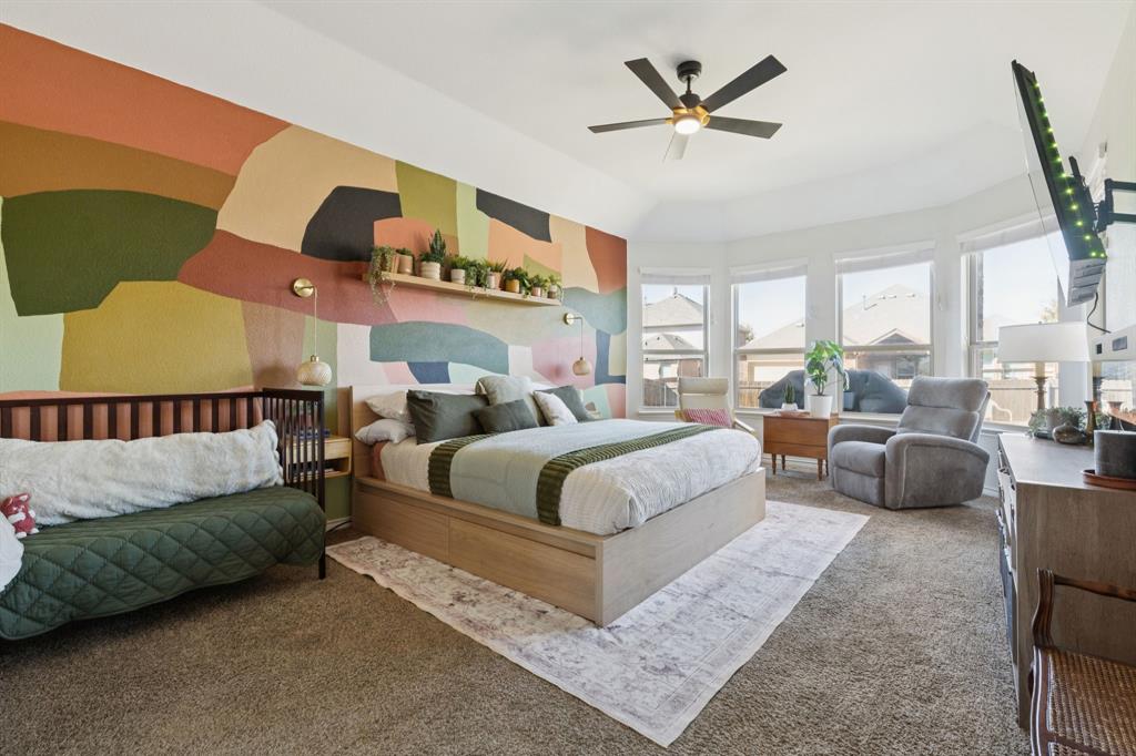 1326 White Water Lane Rockwall, TX 75087 - Photo 11 of 34 a spacious bedroom with a bed a couch and a ceiling fan