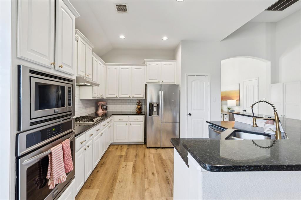 1326 White Water Lane Rockwall, TX 75087 - Photo 7 of 34 a kitchen with kitchen island granite countertop a stove sink and refrigerator