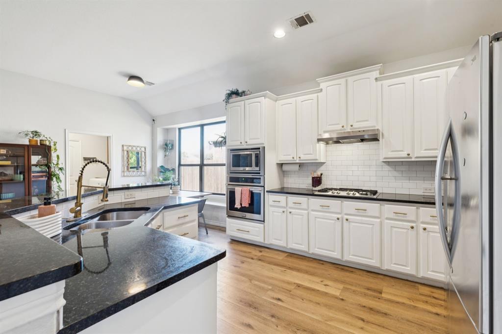 1326 White Water Lane Rockwall, TX 75087 - Photo 8 of 34 a kitchen with stainless steel appliances granite countertop a sink refrigerator and cabinets