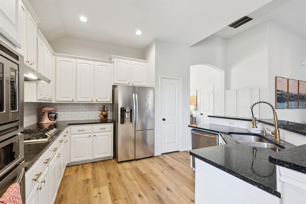 1326 White Water Lane Rockwall, TX 75087 - Photo 9 of 34 a kitchen with stainless steel appliances granite countertop a sink stove and refrigerator