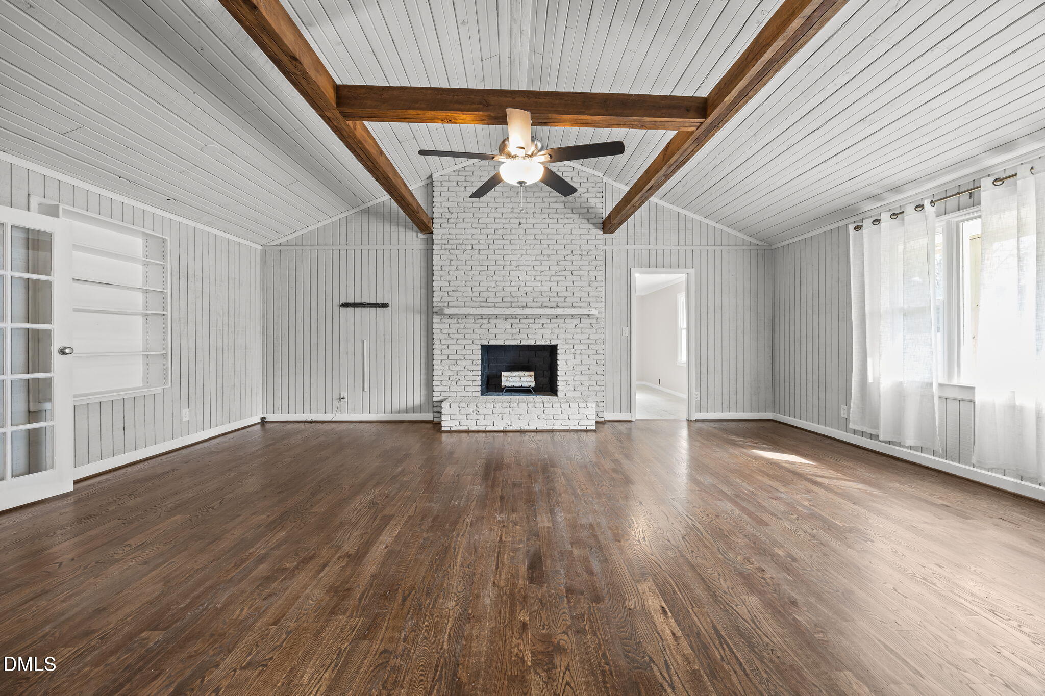 700 Woodland Road Raleigh, NC 27603 - Photo 3 of 35 an empty room with wooden floor fireplace and windows