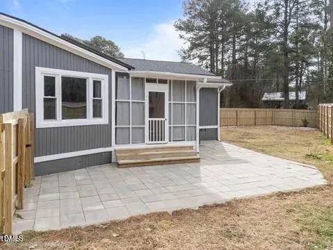 a view of house with backyard and glass windows