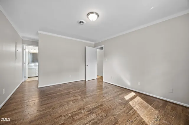 a view of an empty room with wooden floor