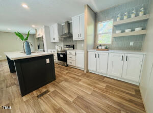 4285 Autry Mill Road Godwin, NC 28344 - Photo 8 of 19 a kitchen with stainless steel appliances granite countertop a sink stove and refrigerator