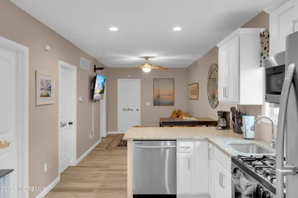 a kitchen with stainless steel appliances granite countertop a sink refrigerator and cabinets