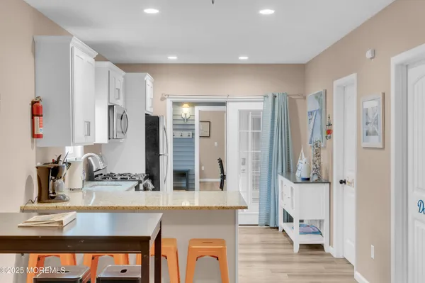 a living room with furniture and a dining table with wooden floor