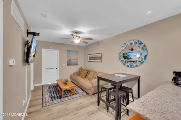 a living room with furniture a ceiling fan and a rug