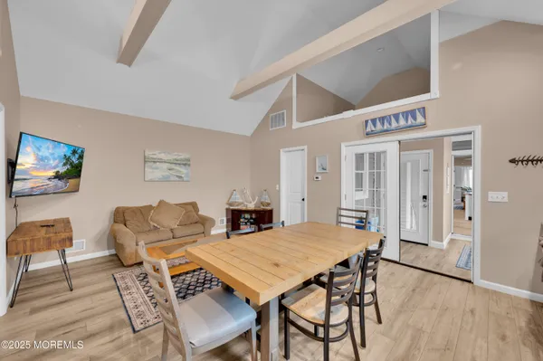 a kitchen with a refrigerator a stove a microwave a dining table and chairs