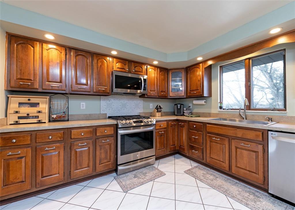 1267 Fall Lane Irwin, PA 15642 - Photo 11 of 22 a kitchen with stainless steel appliances granite countertop a stove sink microwave and window