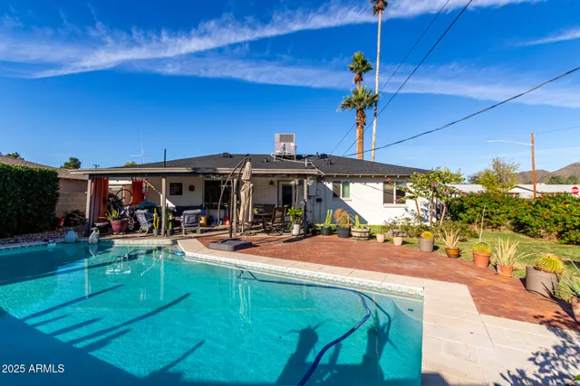 a view of a backyard with table and chairs potted plants