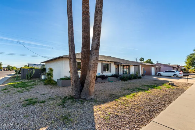 a view of a house with backyard and sitting area