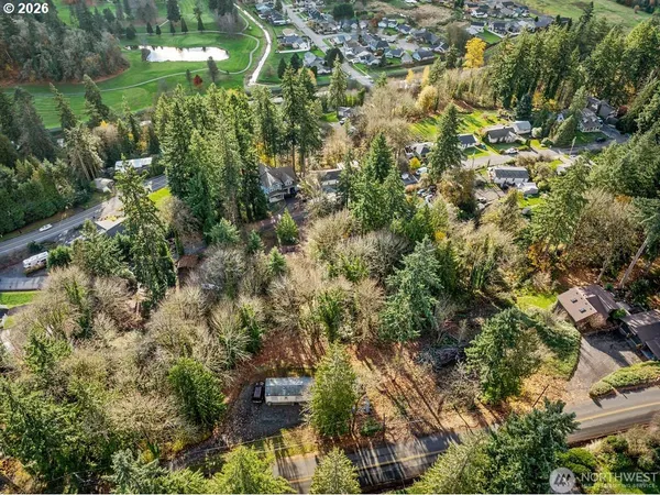 an aerial view of residential house with outdoor space and trees all around