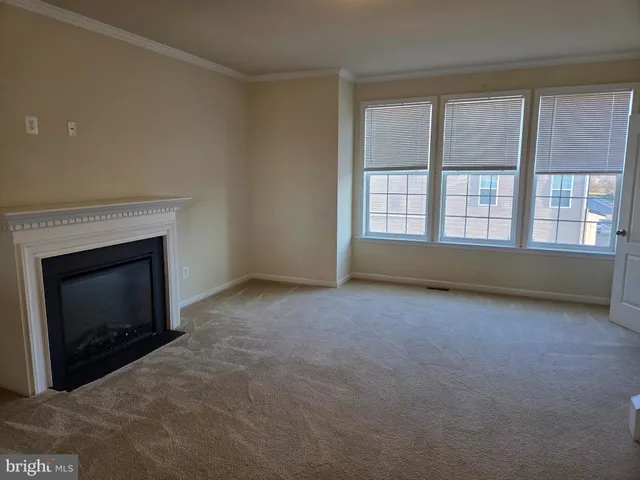 a view of an empty room with a fireplace and a window