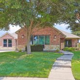 a front view of a house with a yard and trees