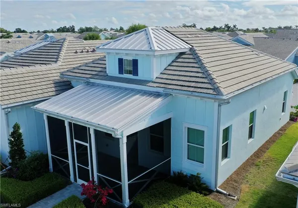 a view of a house with potted plants and a large window