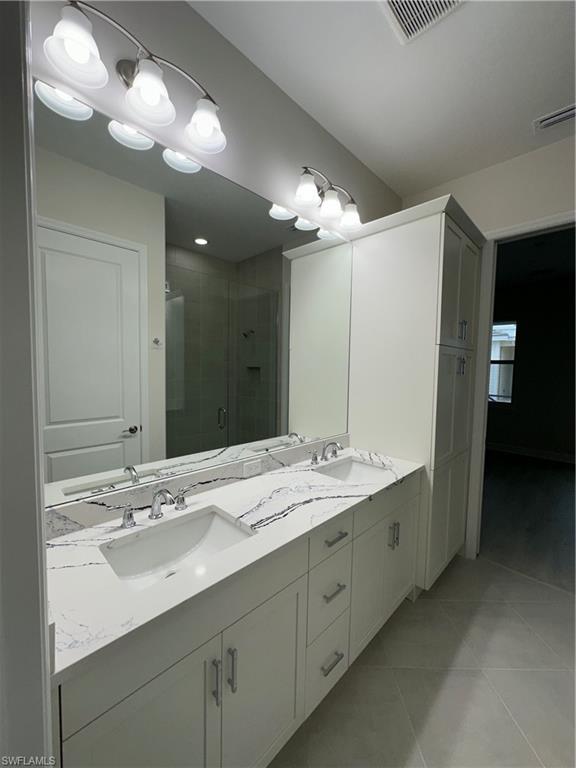 7255 Saona Court Naples, FL 34113 - Photo 14 of 28 a bathroom with a sink double vanity and a mirror