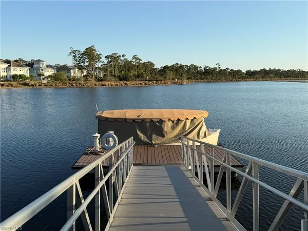 a front view of house with lake view and trees in the background