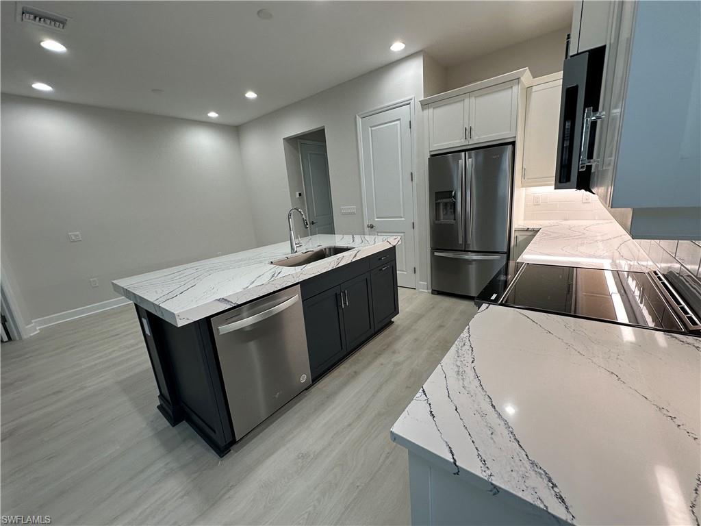 7255 Saona Court Naples, FL 34113 - Photo 6 of 28 a kitchen with a sink and a refrigerator