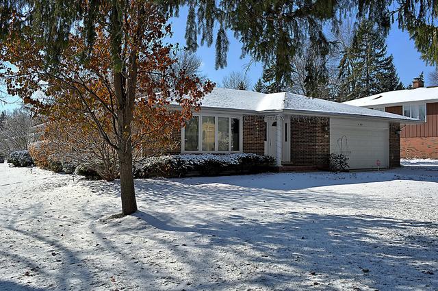 a front view of a house with a yard covered in snow