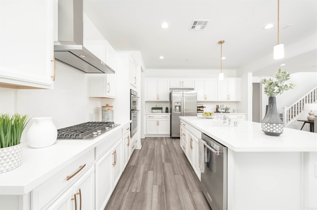 33288 Skyview Road Winchester, CA 92596 - Photo 11 of 51 a kitchen with stainless steel appliances kitchen island granite countertop a sink a stove and a refrigerator