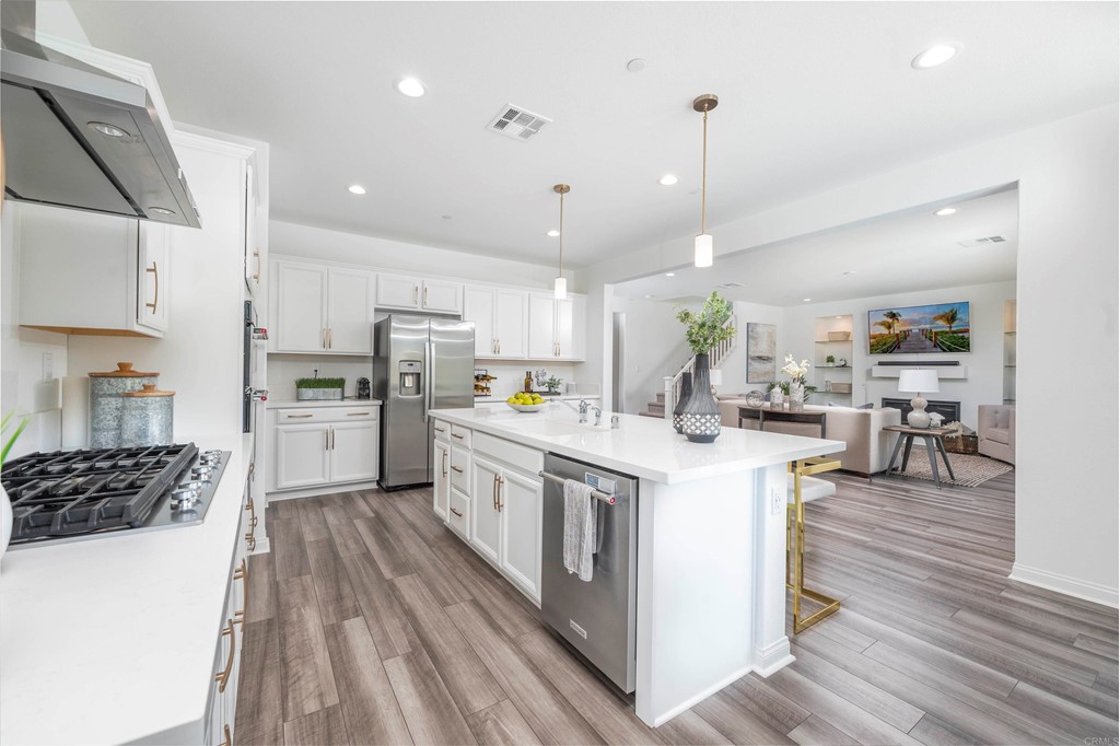33288 Skyview Road Winchester, CA 92596 - Photo 12 of 51 a kitchen with kitchen island a white counter top space a stove a refrigerator cabinets and wooden floor